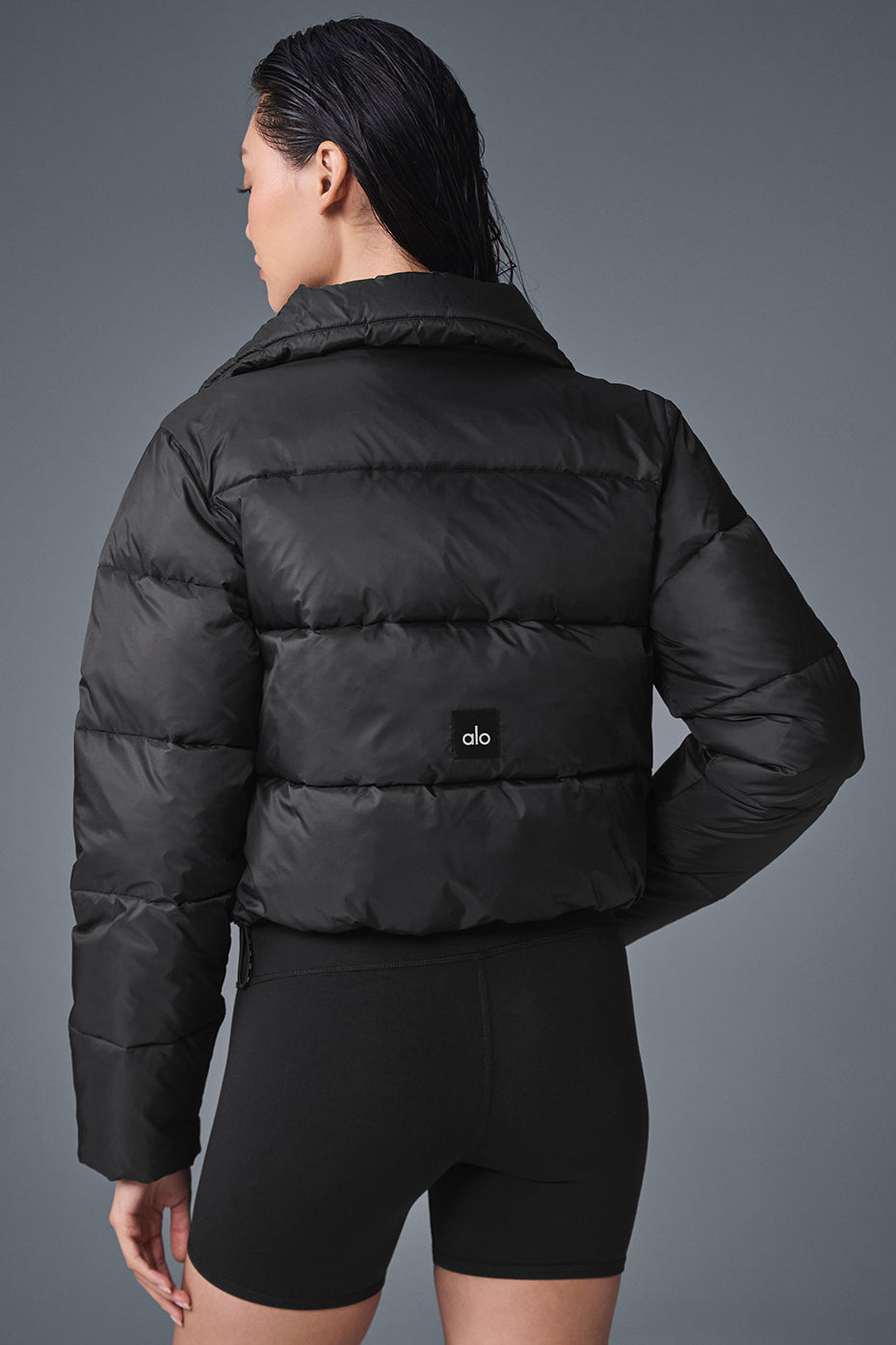 Back view of the Gold Rush Black Puffer Jacket highlighting the cropped design