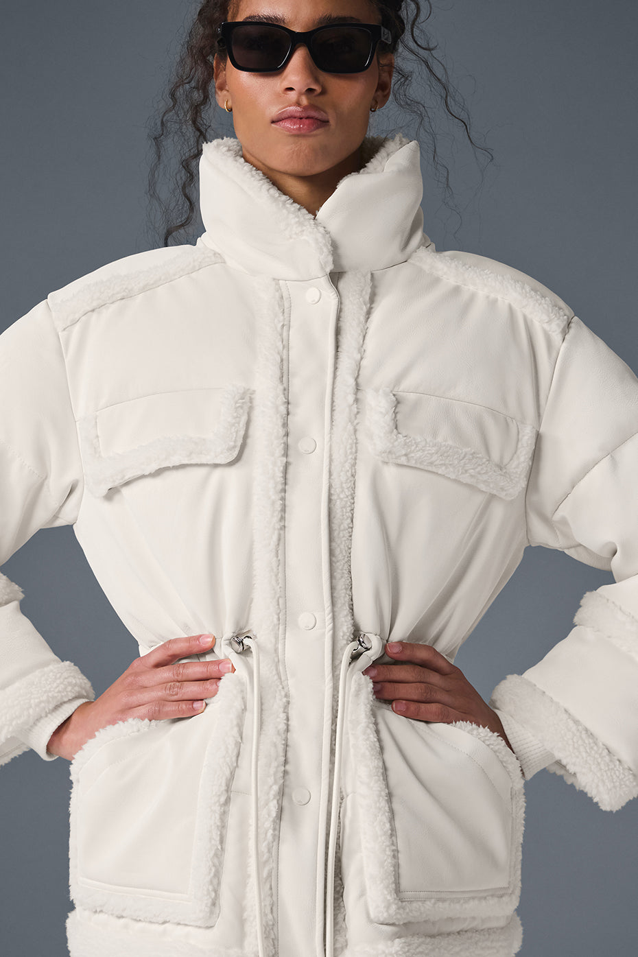 Ivory puffer jacket displayed outdoors in a snowy setting.
