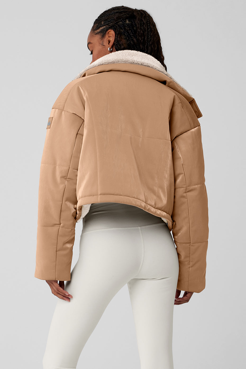 Side angle of the cropped puffer jacket with cinched bungee drawcord.