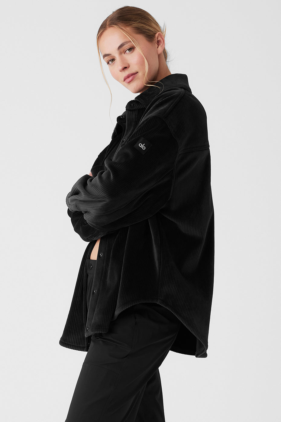 Model wearing the black shacket over leggings, highlighting its versatility.