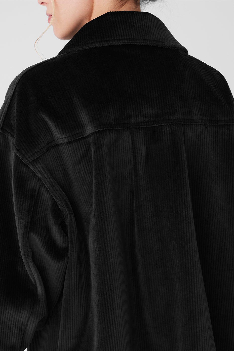 Front view of the black ribbed velour shacket on a model, showcasing its stylish design.