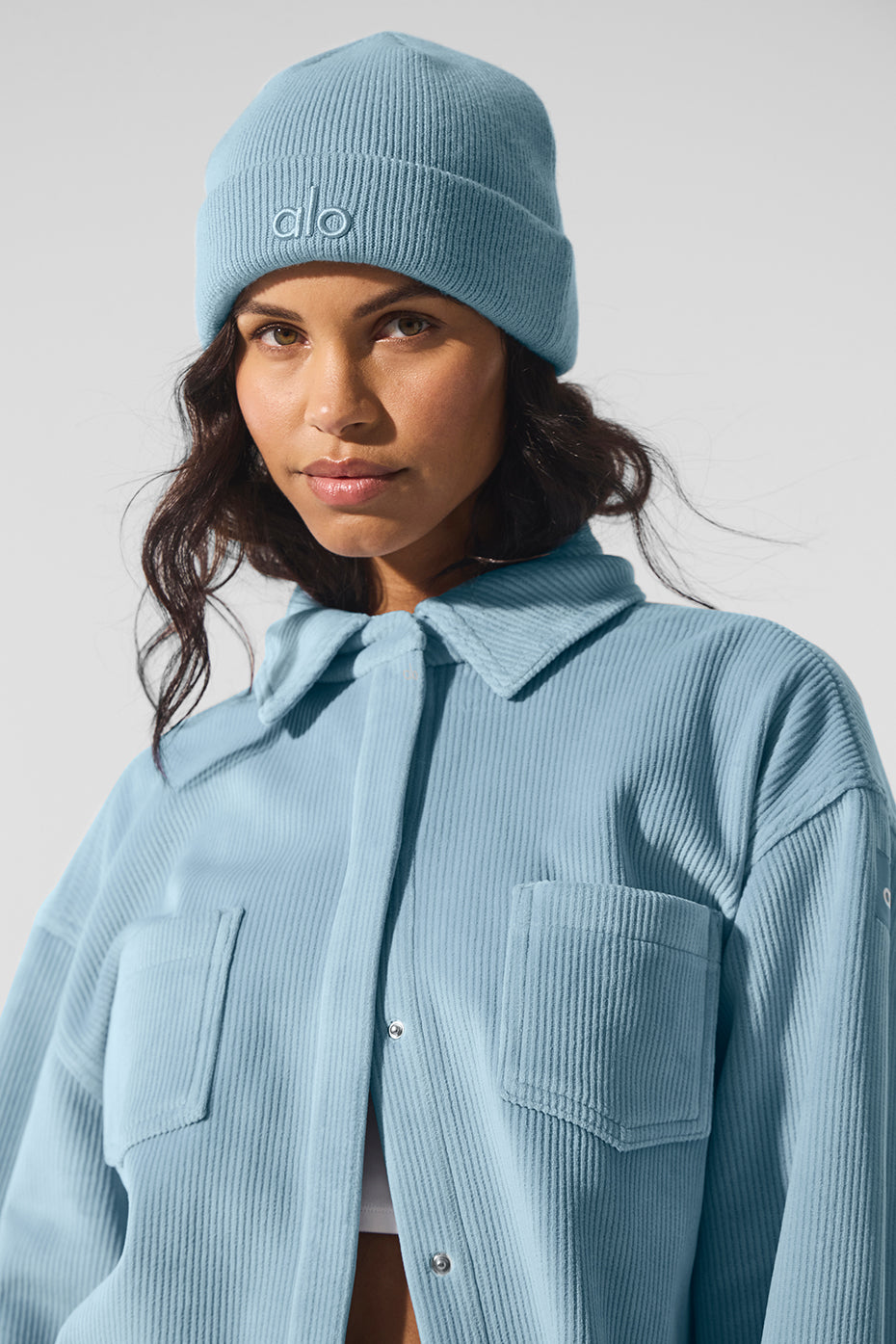 Side profile of womens outerwear featuring darted sleeves and celestial blue ribbed texture
