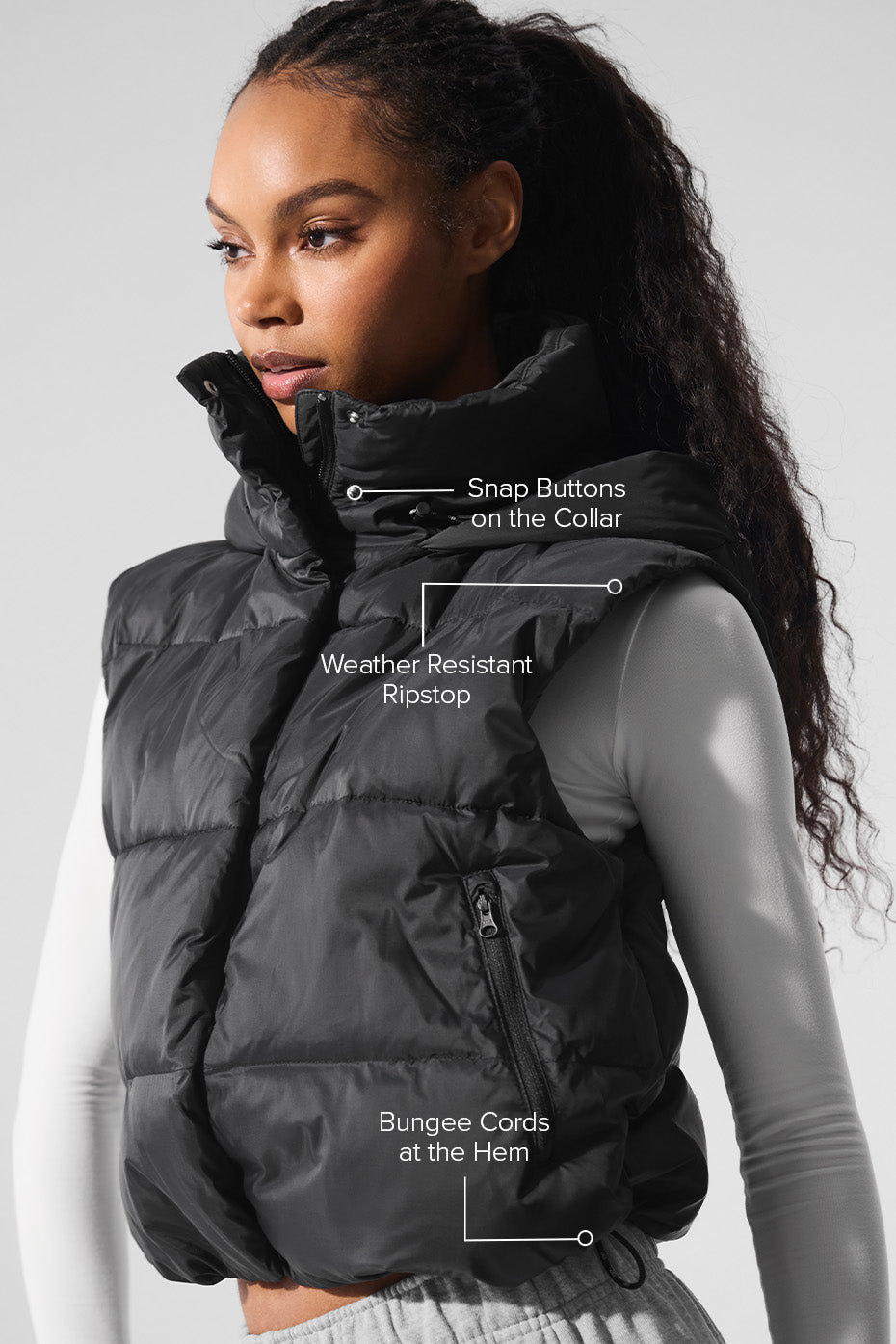 Model wearing the cropped puffer vest layered over a sweater for transitional weather