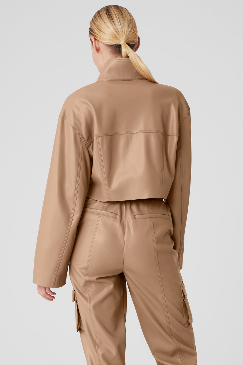 Model wearing the faux leather jacket styled with joggers.
