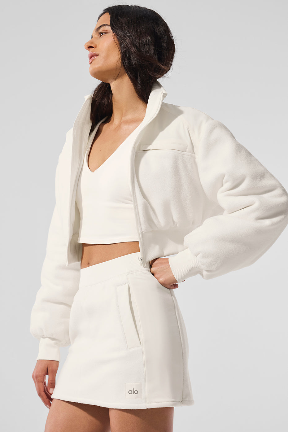 Front view of ivory cropped polar fleece jacket with zippered pocket