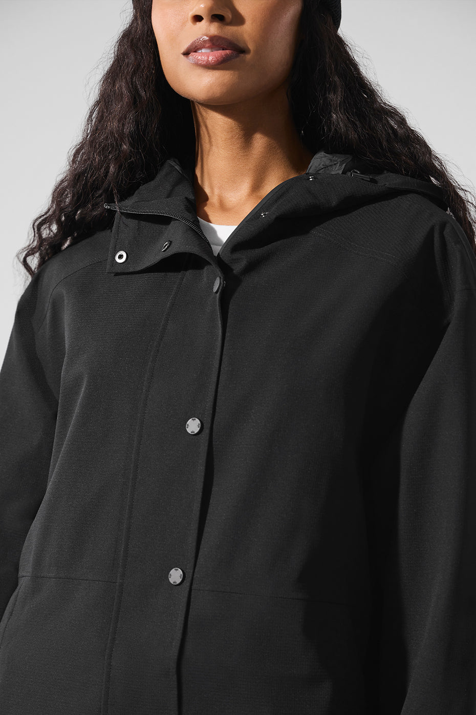 Woman wearing the ladies long waterproof coat while walking in the rain.