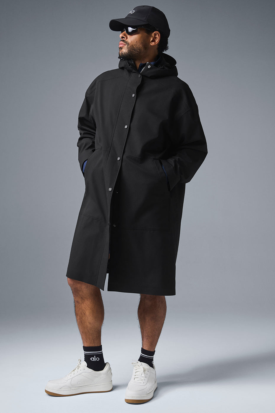 Front view of the waterproof long coat in black, showcasing the tall collar and hood.