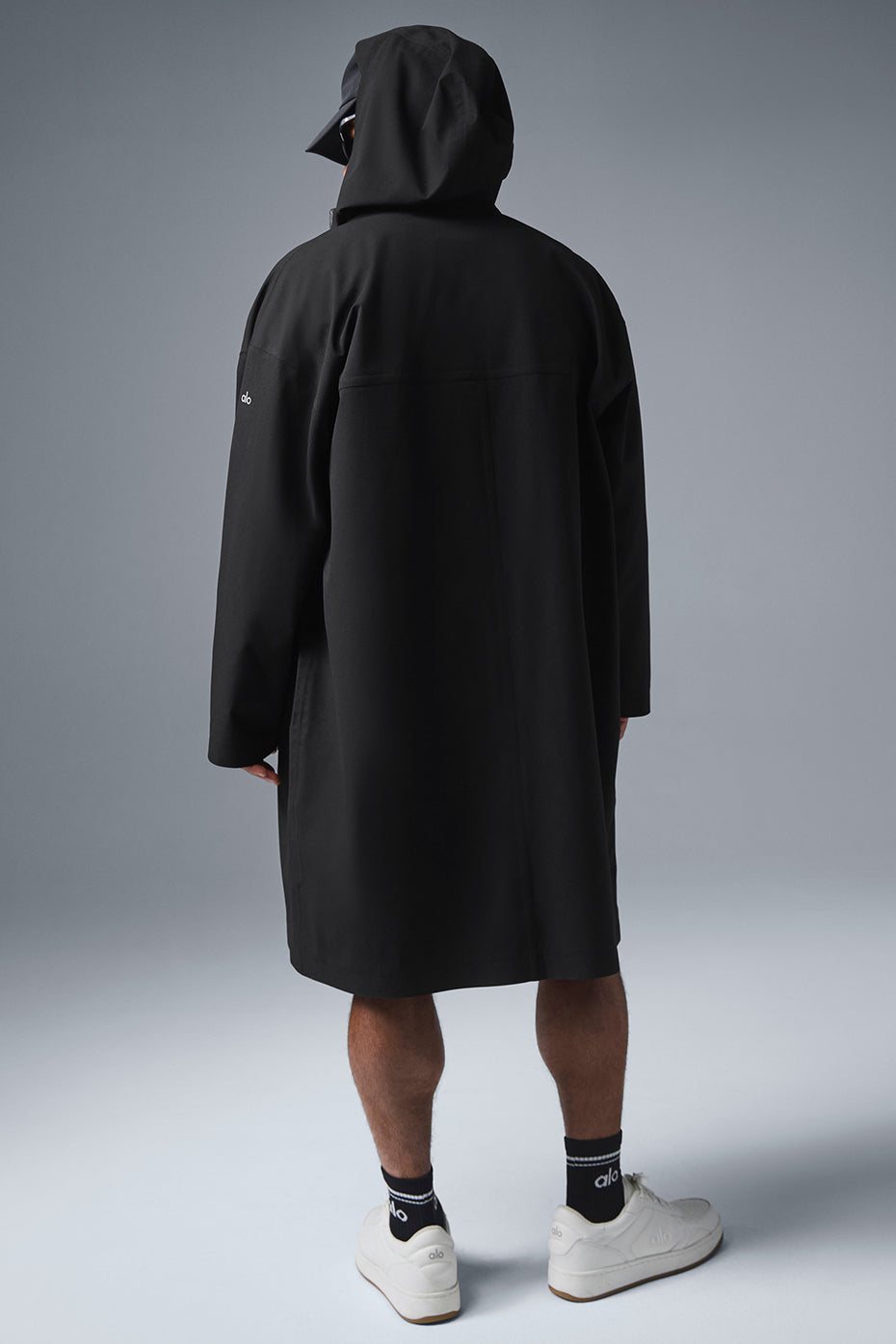 Front view of the waterproof long coat in black, showcasing the tall collar and hood.