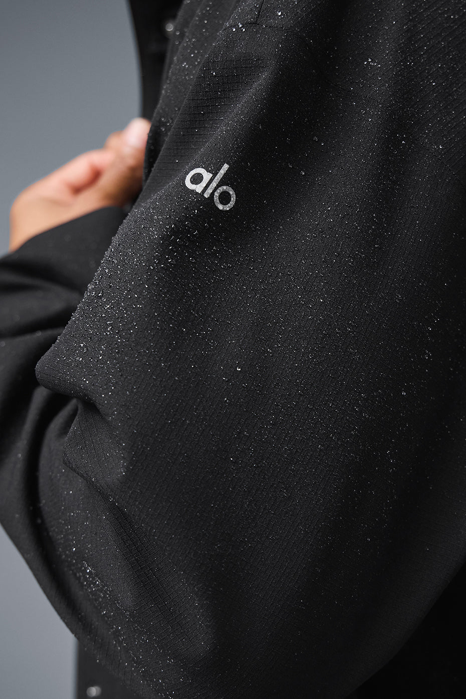 Side view of the long coat, highlighting the zippered pockets and relaxed fit.
