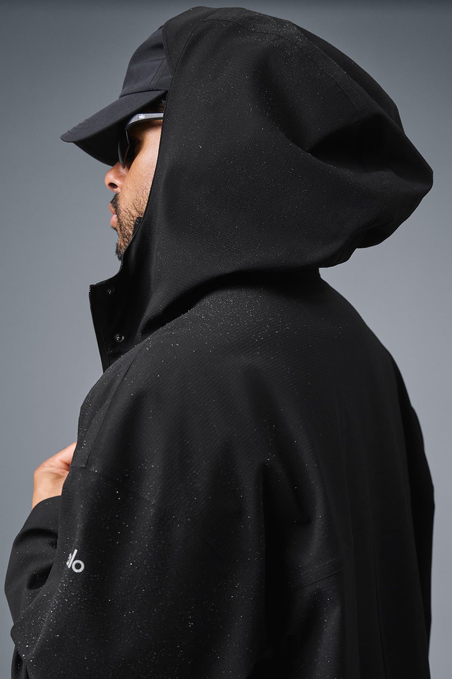 Back view of the long coat, demonstrating its sleek design and waterproof material.
