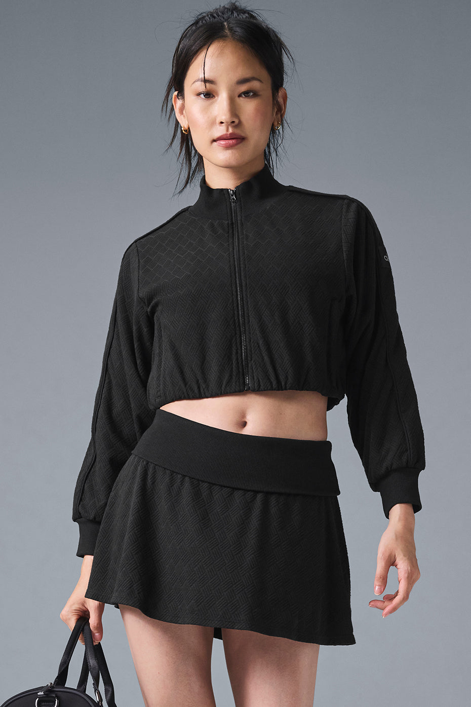 Model wearing cropped leather jacket with ribbed collar from side view