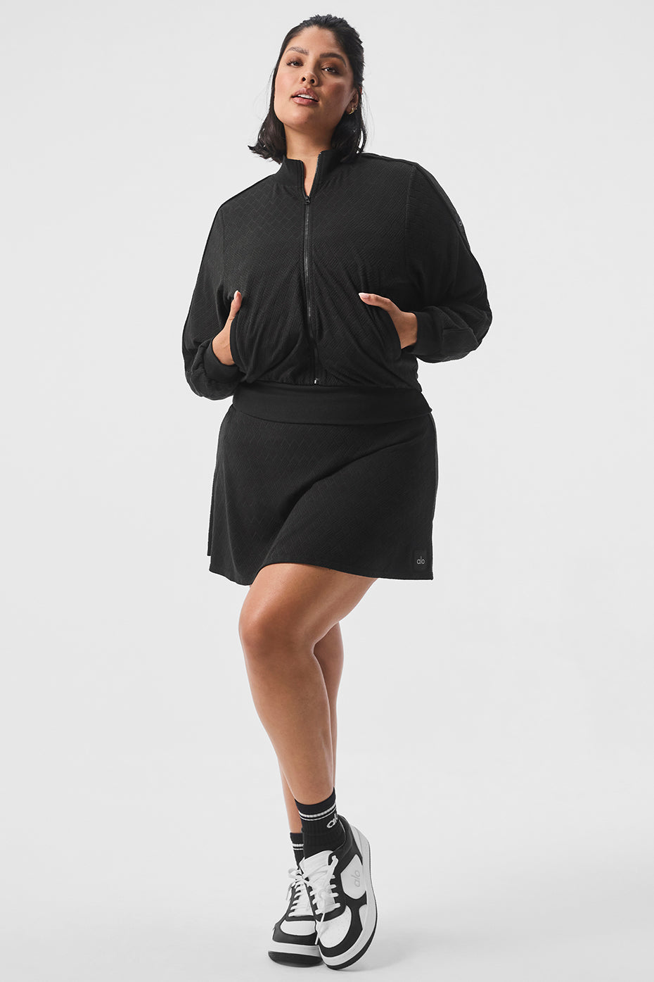 Back view of cropped puffer jacket showing elastic hem and piping