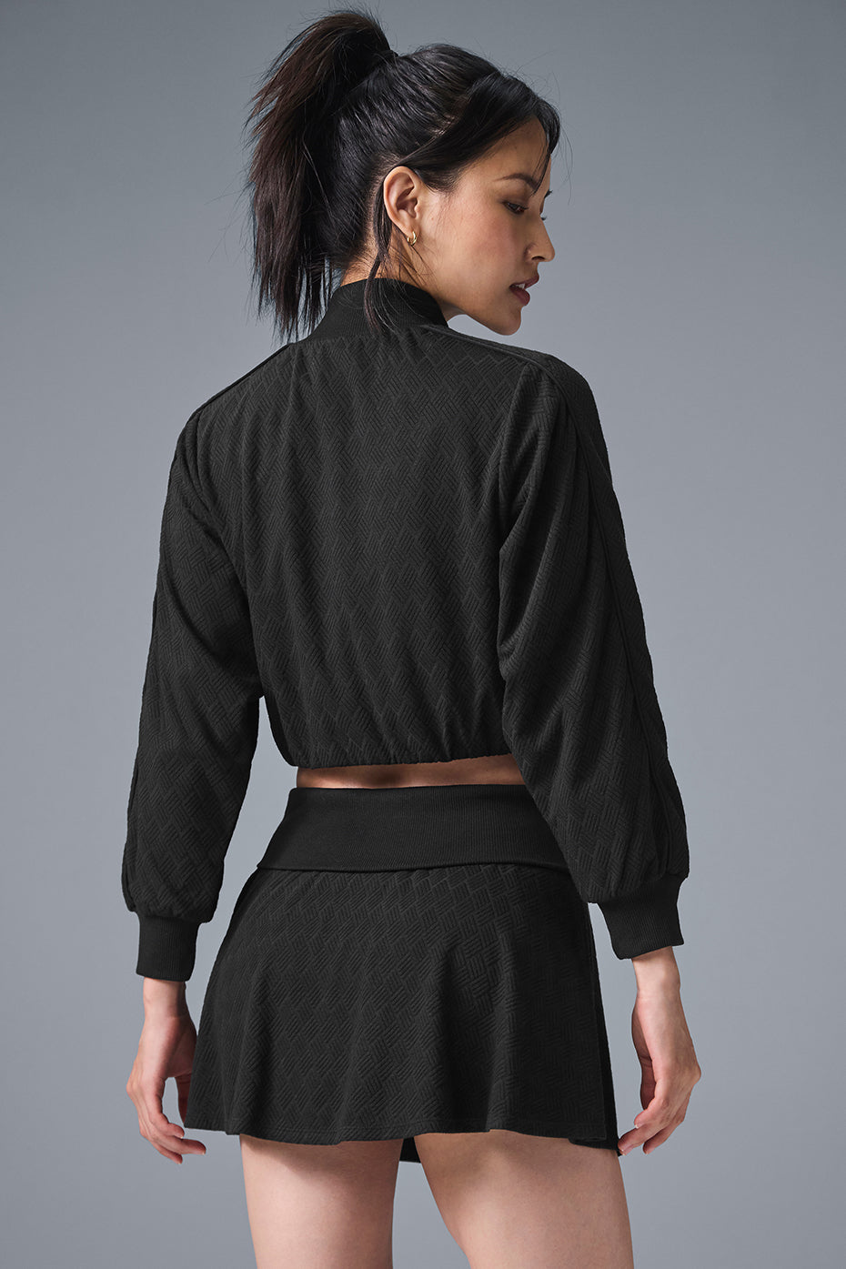 Close-up of cropped denim jackets zippered pockets and rib detailing