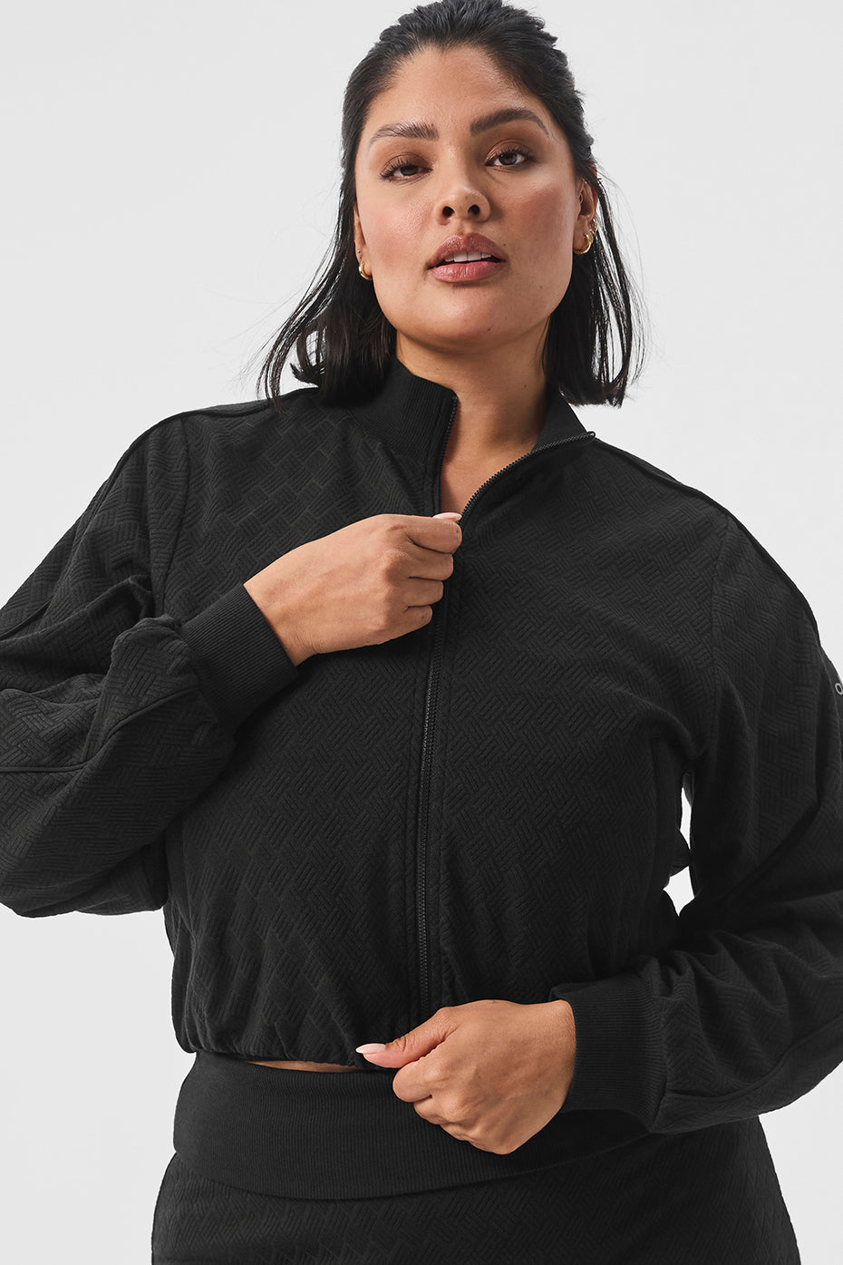Close-up of cropped denim jackets zippered pockets and rib detailing