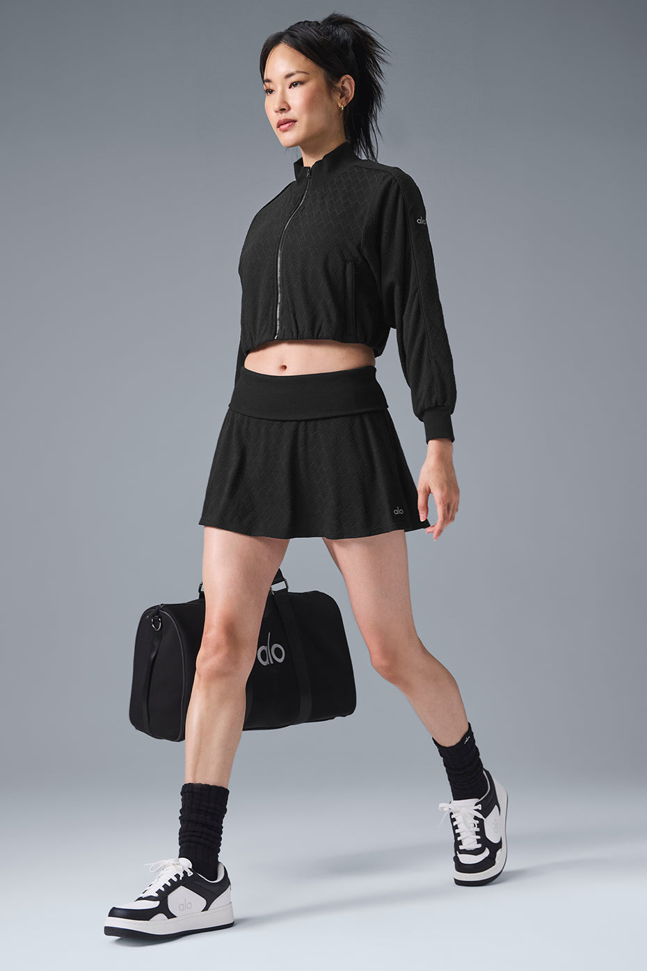 Back view of cropped puffer jacket showing elastic hem and piping