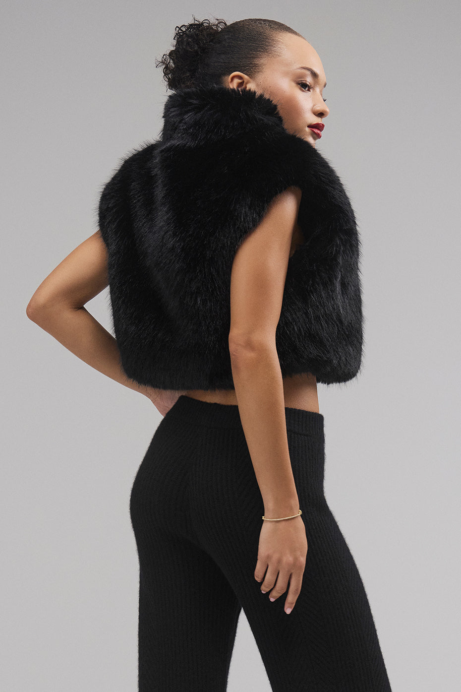 Woman wearing crop puffer vest on a city street in fall