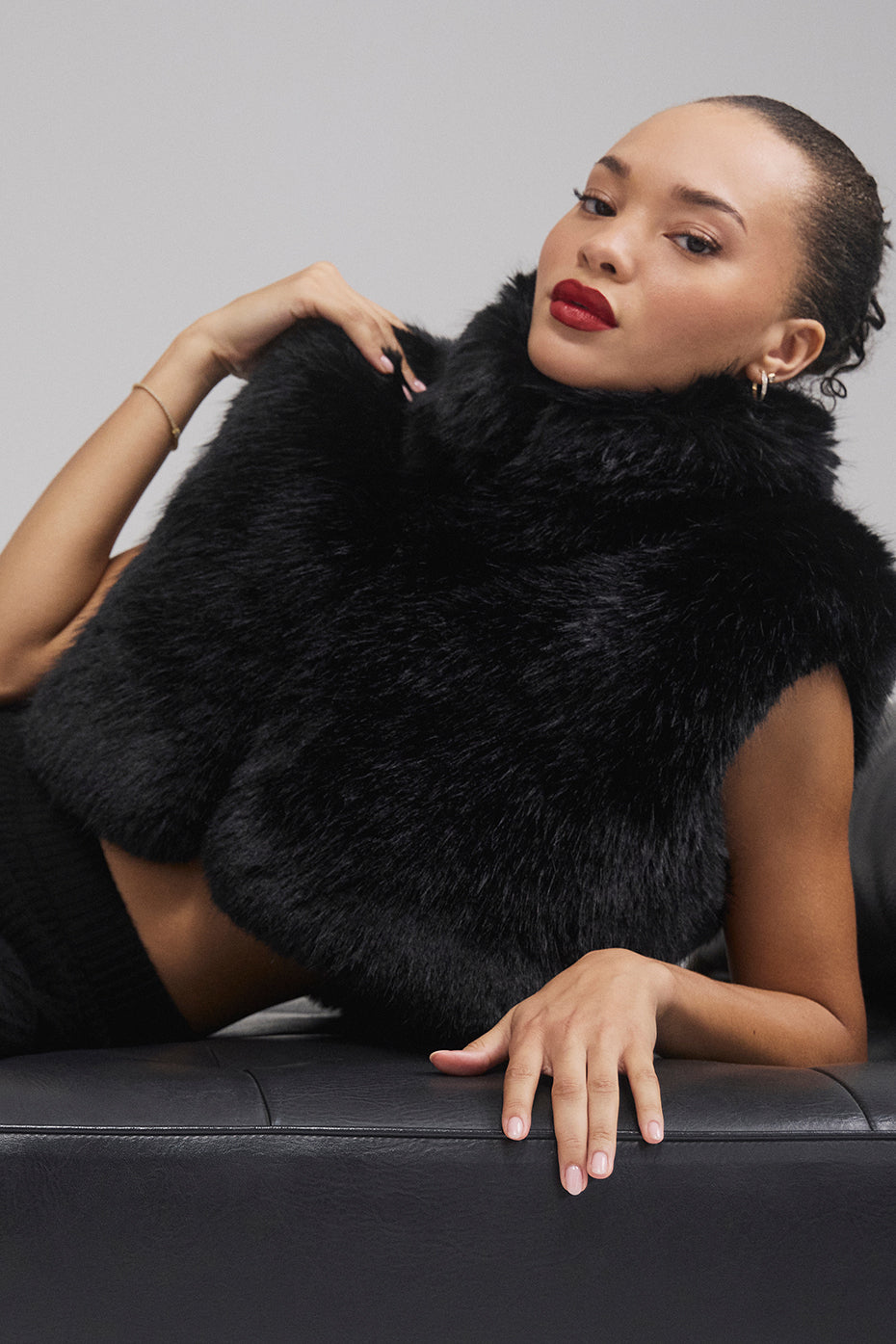 Close-up of black cropped vest collar and faux fur texture