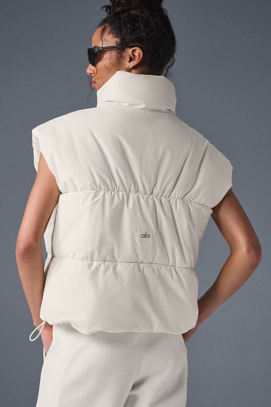 Model wearing the ivory puffer vest at a farmers market.