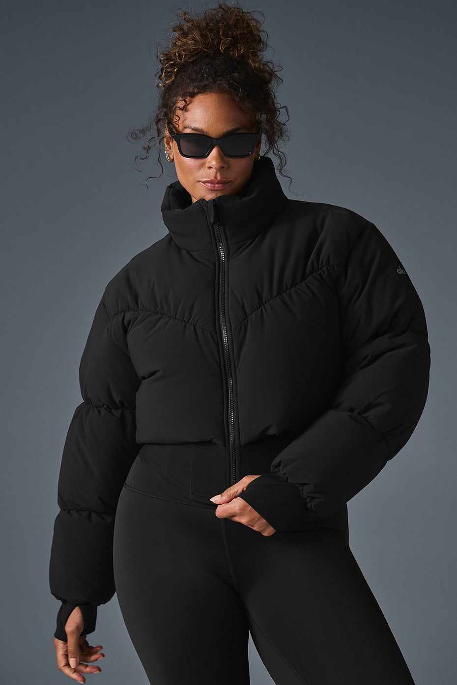 Back view of the black corset puffer jacket highlighting the unique hemline.