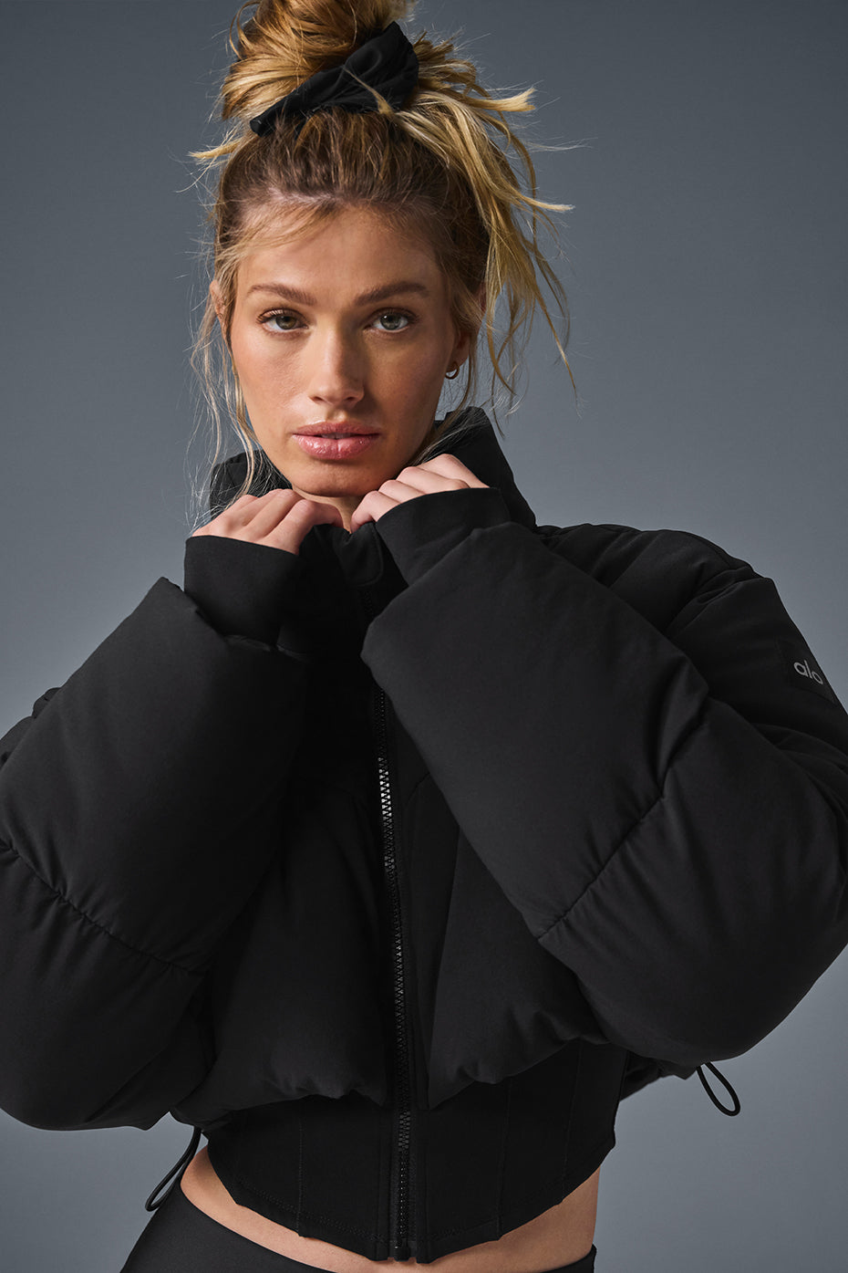 Front view of the black corset puffer jacket on a model outdoors.