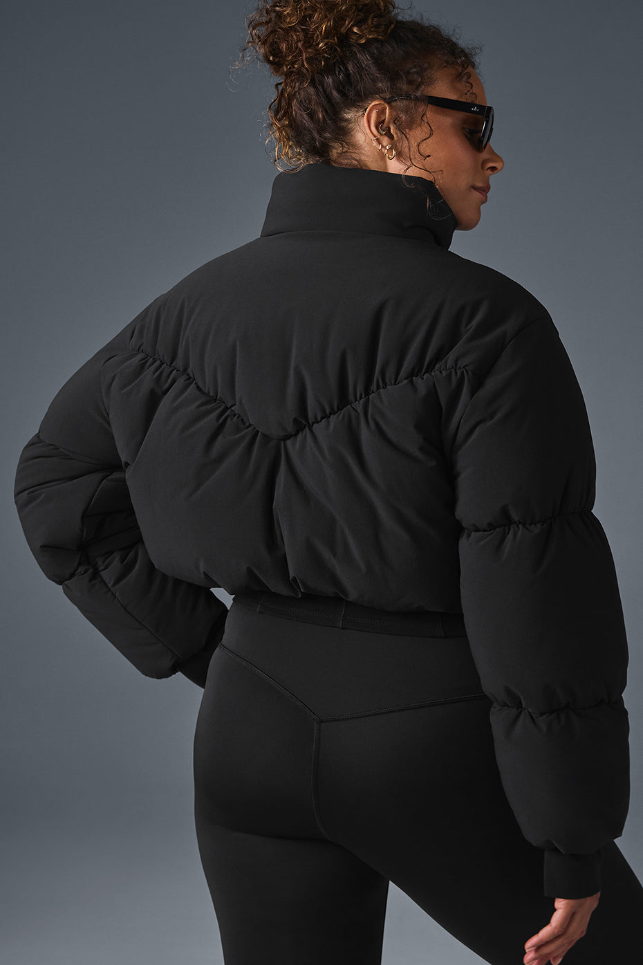 Front view of the black corset puffer jacket on a model outdoors.