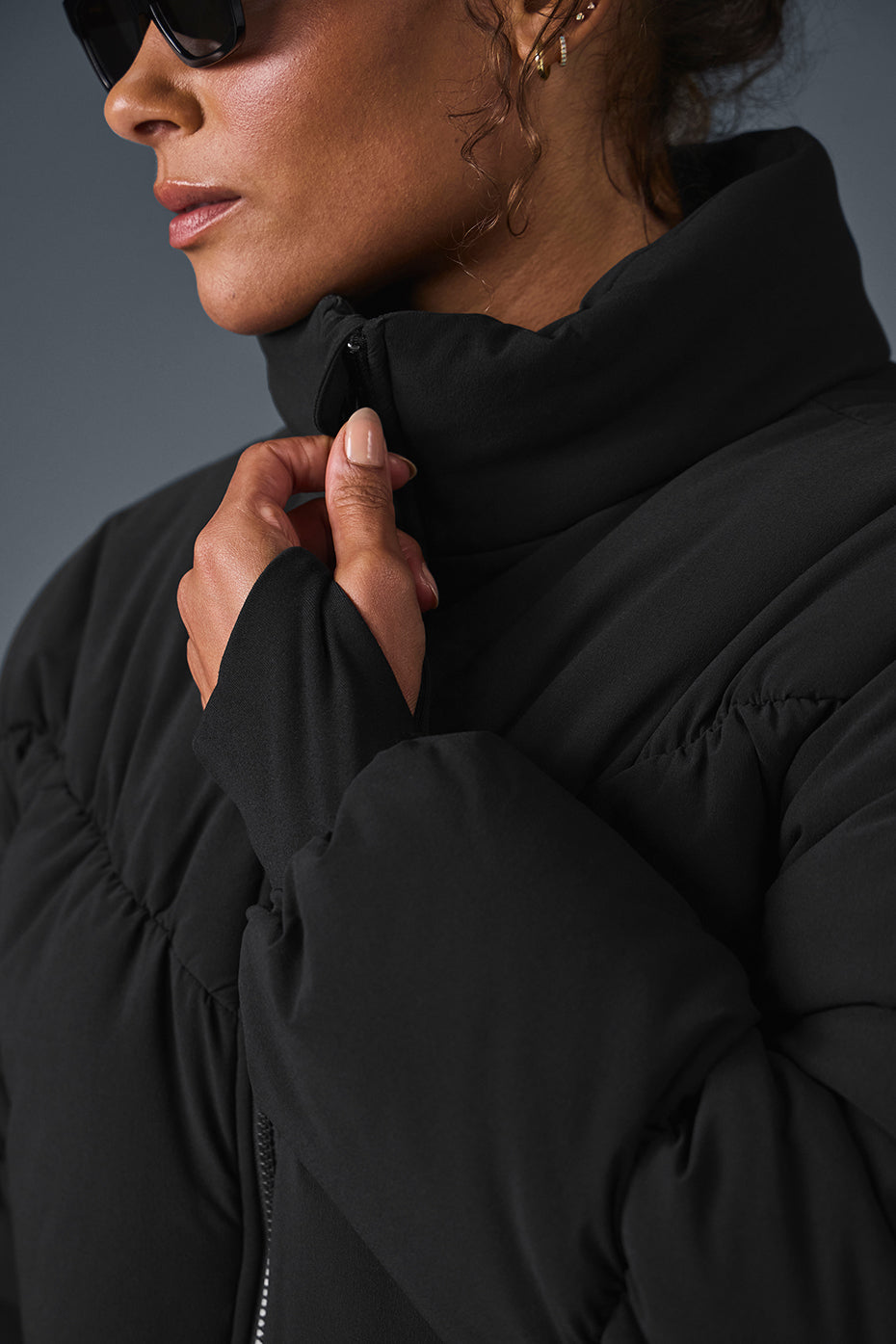 Back view of the black corset puffer jacket highlighting the unique hemline.