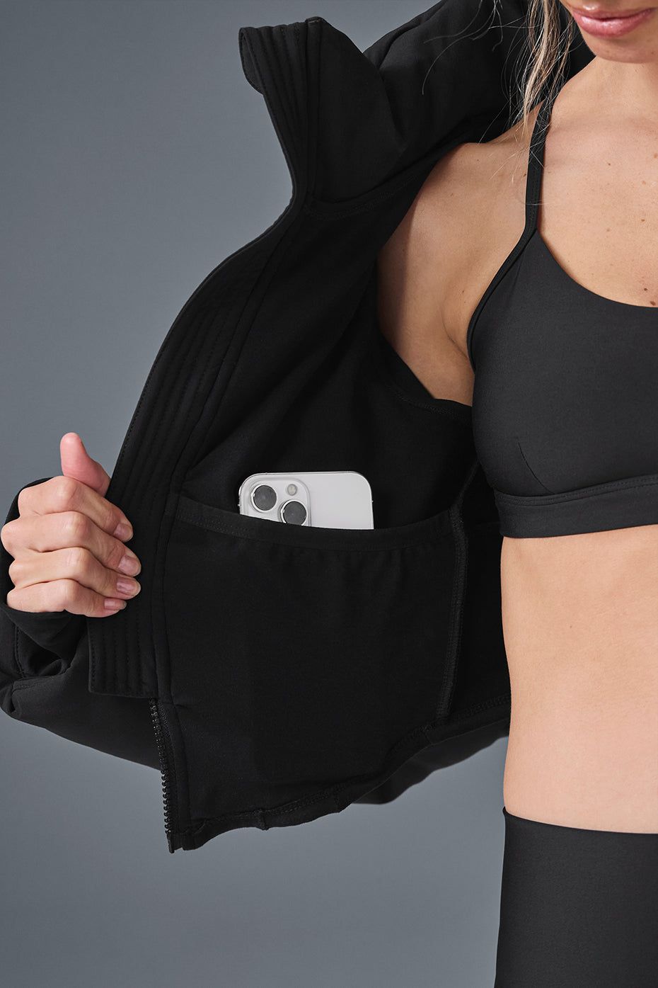 Back view of the black corset puffer jacket highlighting the unique hemline.