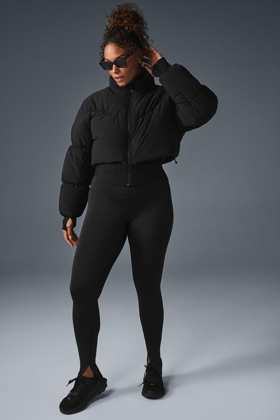 Front view of the black corset puffer jacket on a model outdoors.