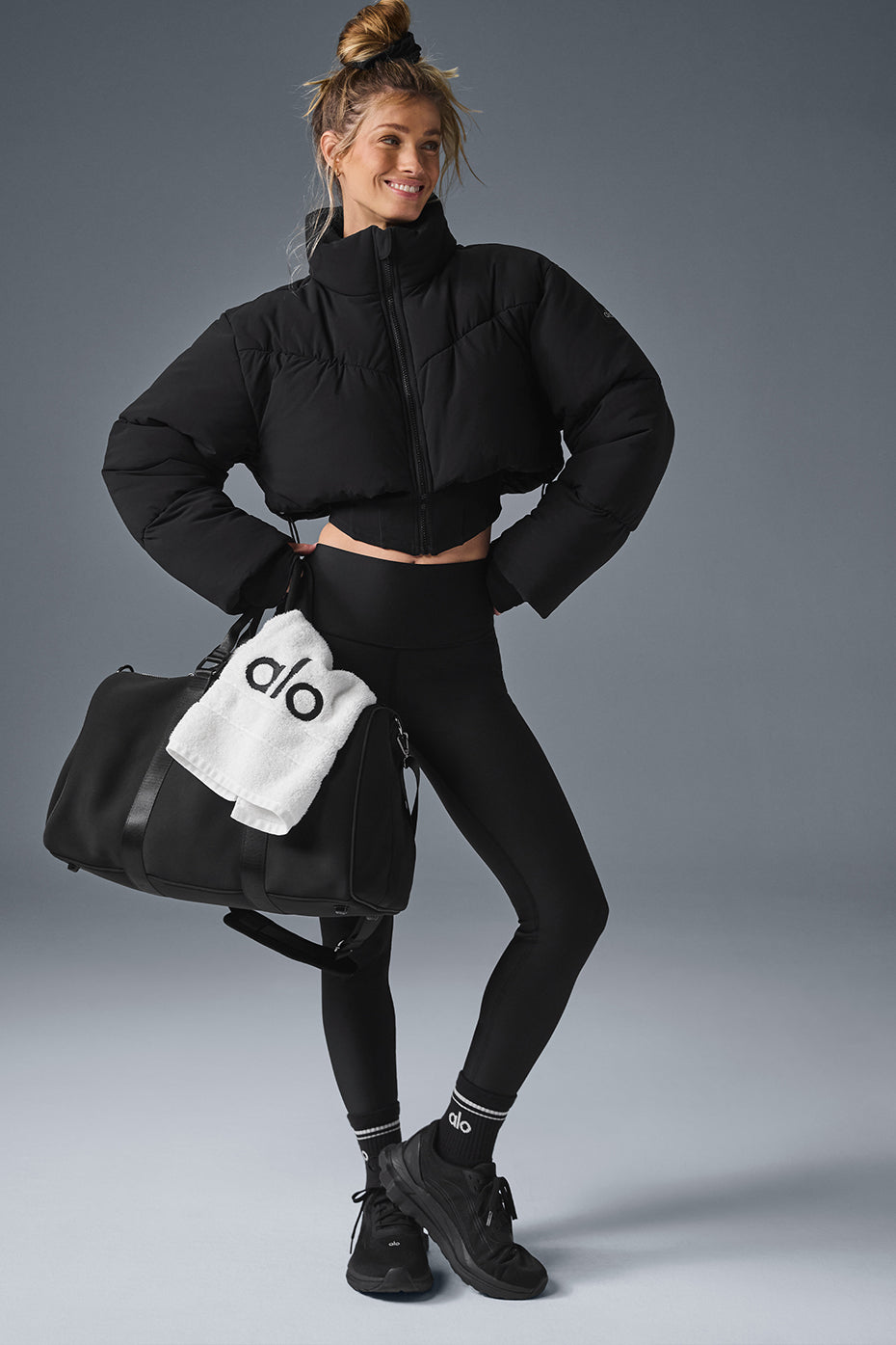 Side angle of the stylish black puffer jacket showcasing its cropped silhouette.