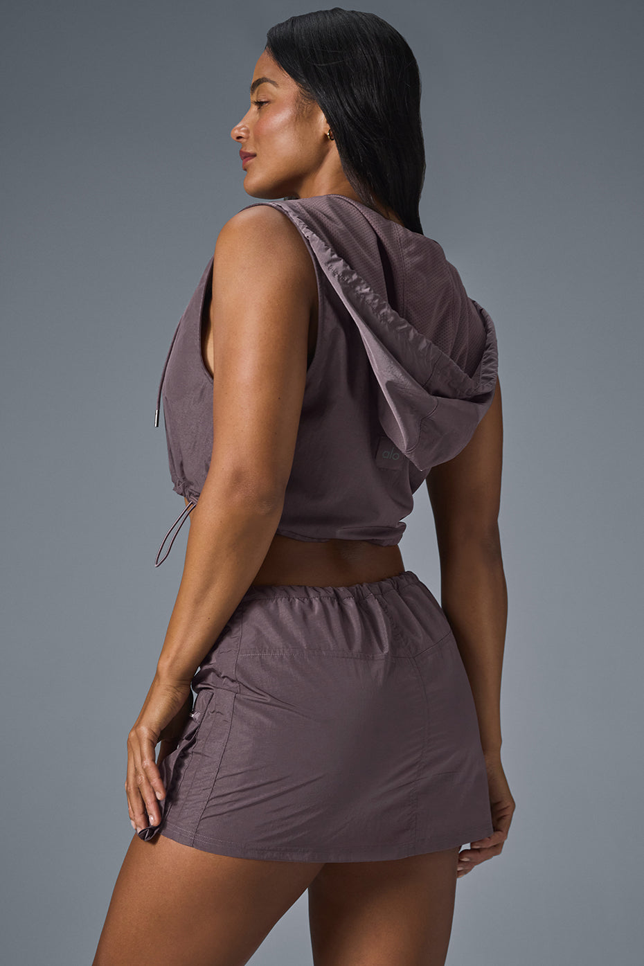 Side view of the cropped puffer vest with adjustable bungee cords.