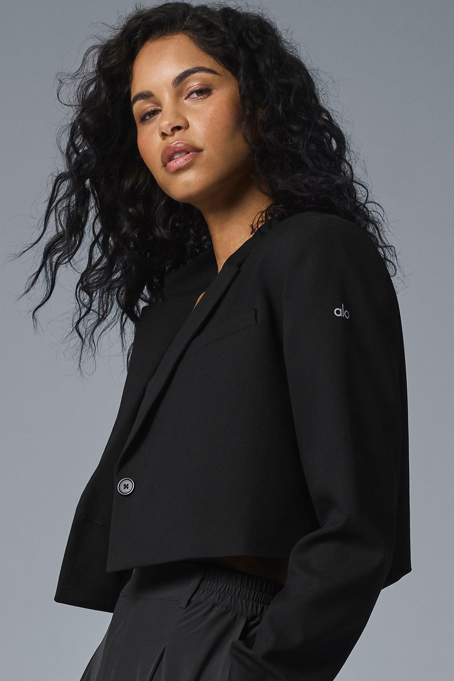 Model wearing oversized black blazer with tailored trousers, showcasing professional styling