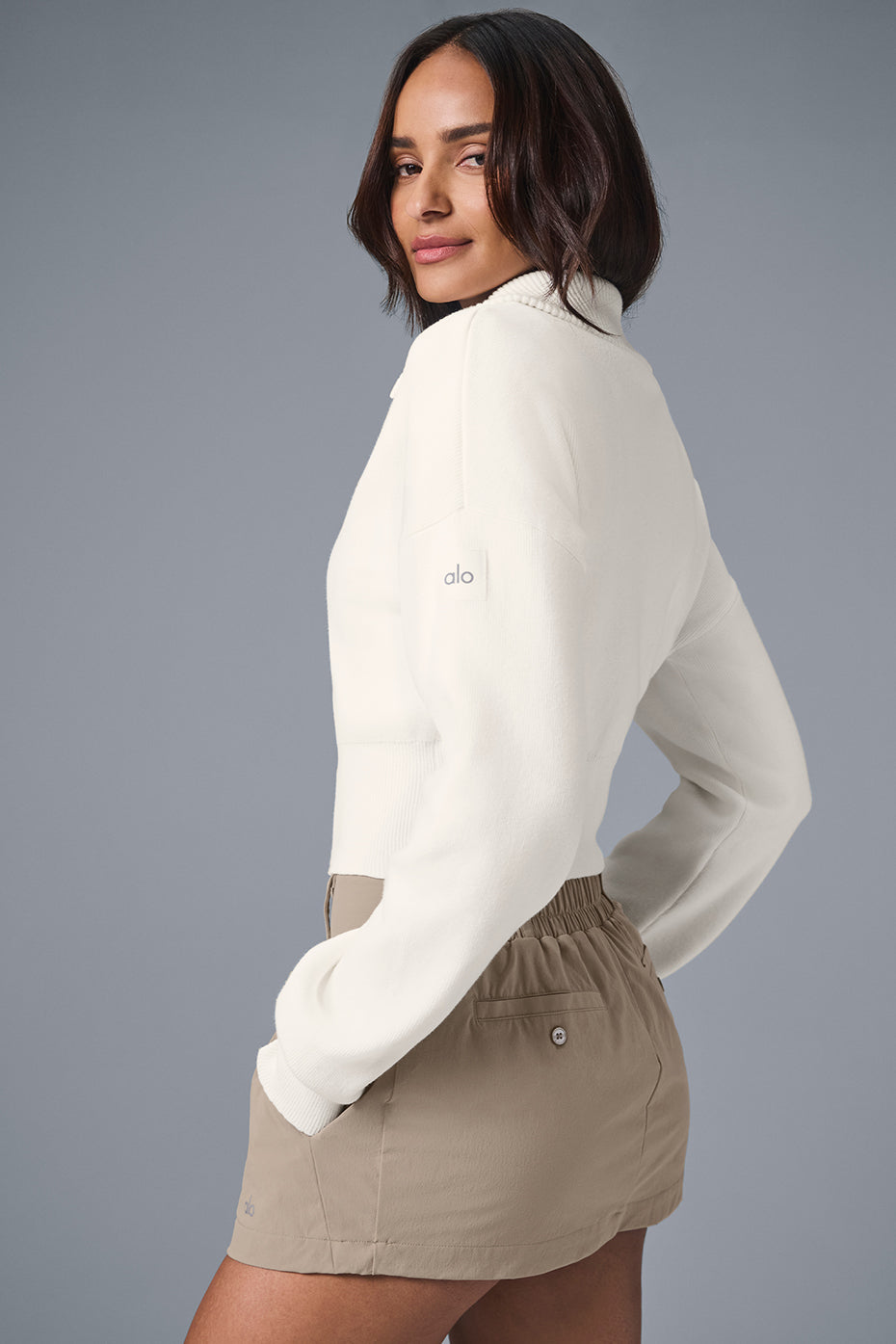 Model enjoying a breezy beach day in the Scholar Knit Cropped Jacket, perfect for warm weather.