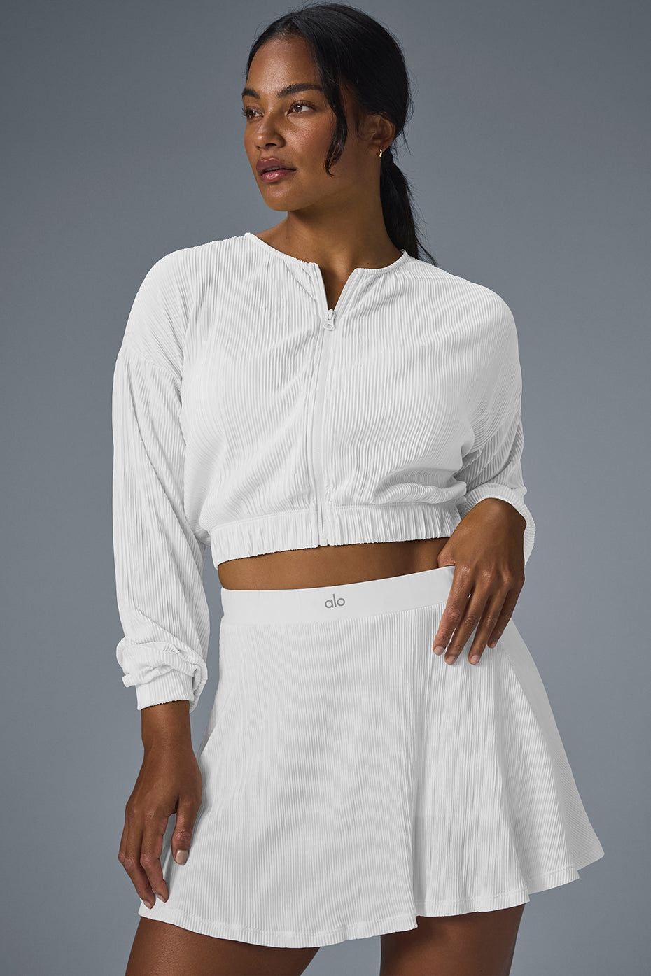 White micro plisse jacket draped over a chair, showcasing its crinkled texture