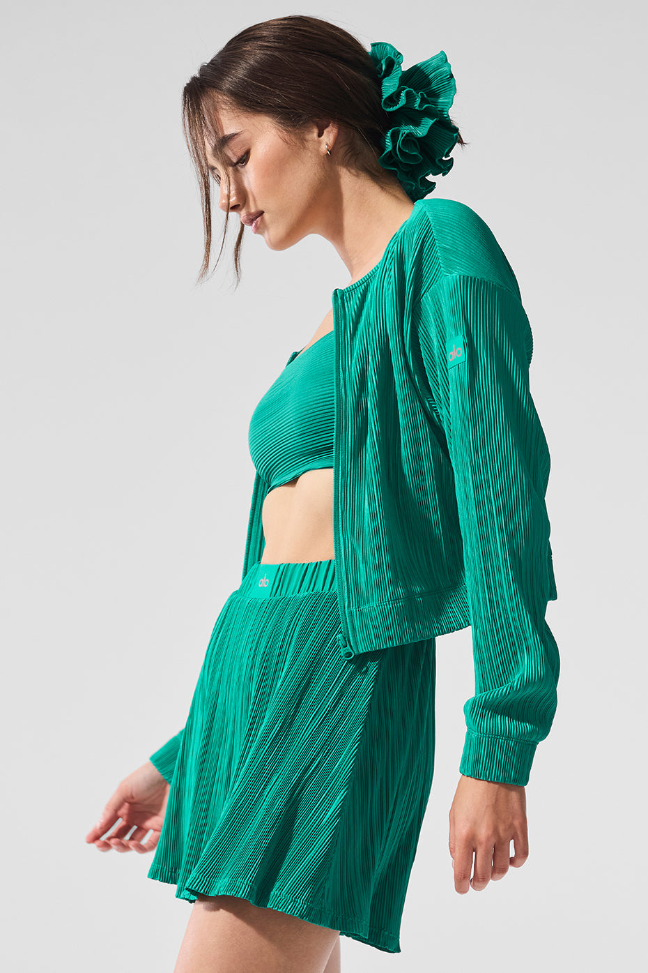 Front view of cropped micro plisse jacket in spruce green with billowy sleeves