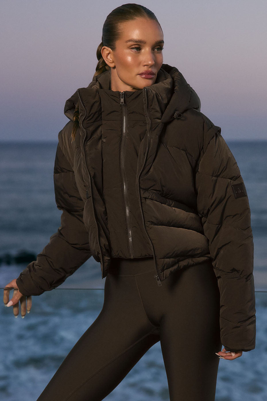 Front view of the black puffer jacket on model walking in urban street