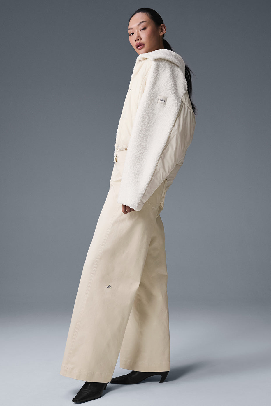 Model wearing the womens sherpa jacket layered over a sweater for a chic urban look