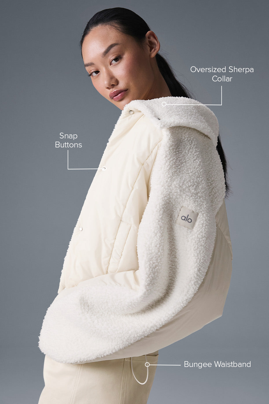 Model wearing the womens sherpa jacket layered over a sweater for a chic urban look