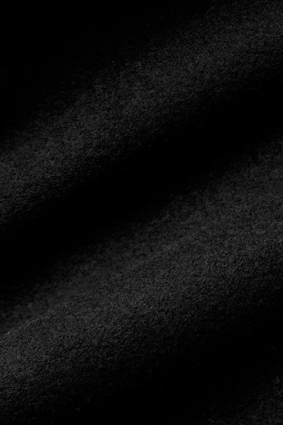 Close-up of the belted sleeves on a black wool trench coat.