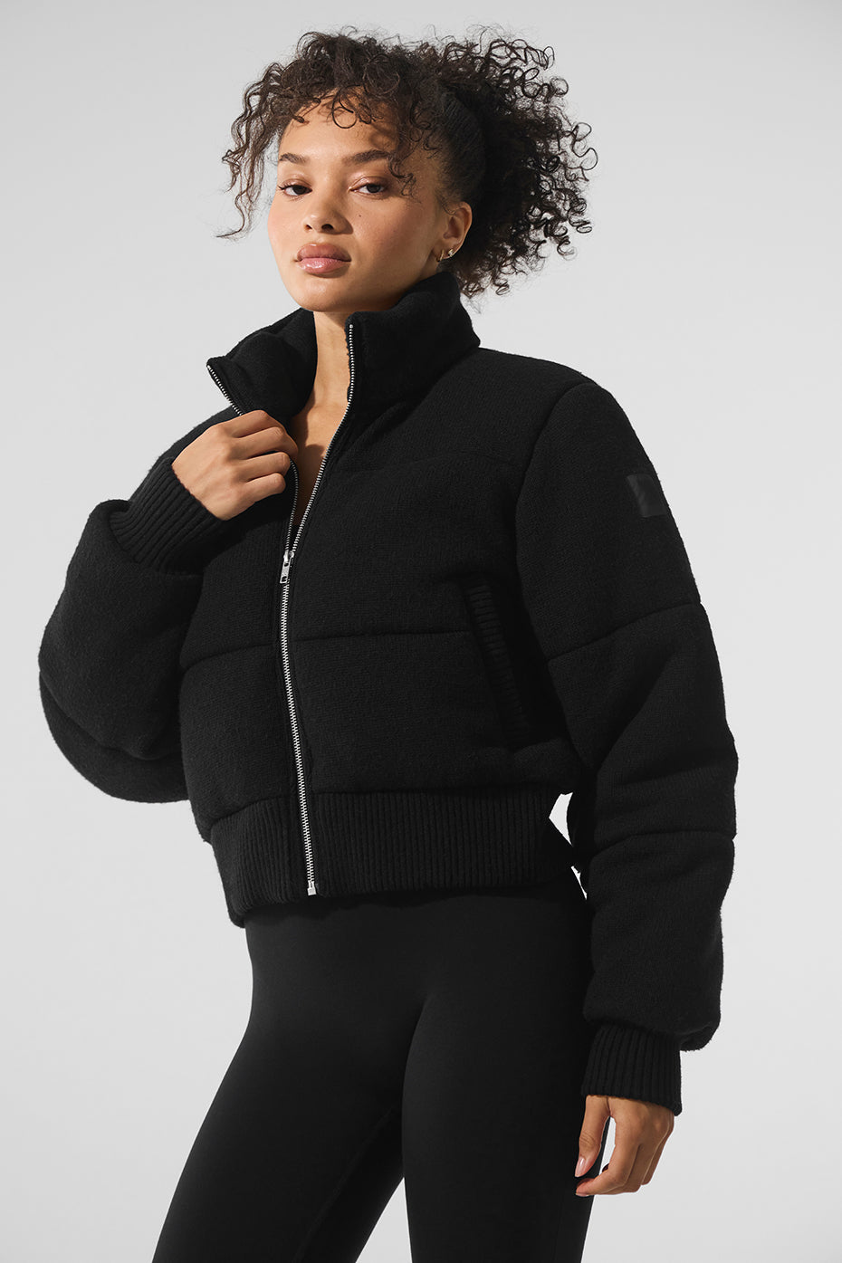 Black sweater puffer jacket layered over a turtleneck