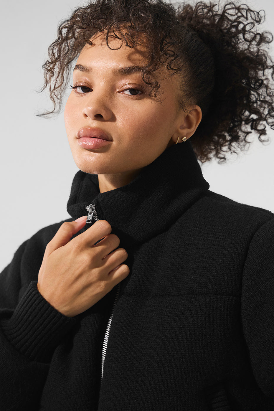 Black sweater puffer jacket layered over a turtleneck