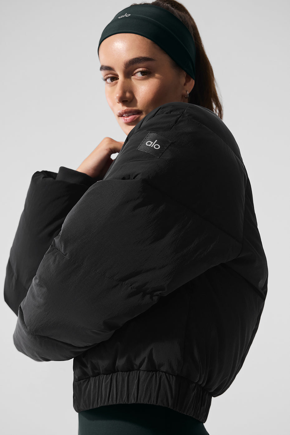 Model wearing the black puffer jacket at a coffee shop