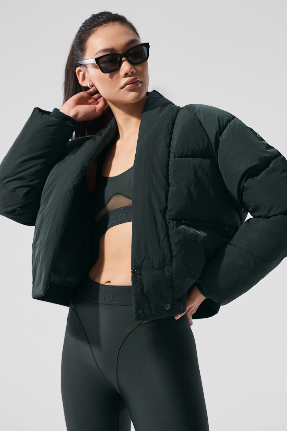Model wearing the charcoal green puffer jacket in a city setting