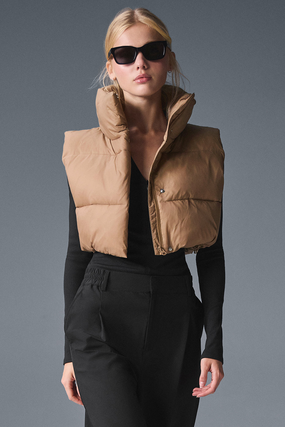 Front view of the cropped gold rush puffer vest in toasted almond.