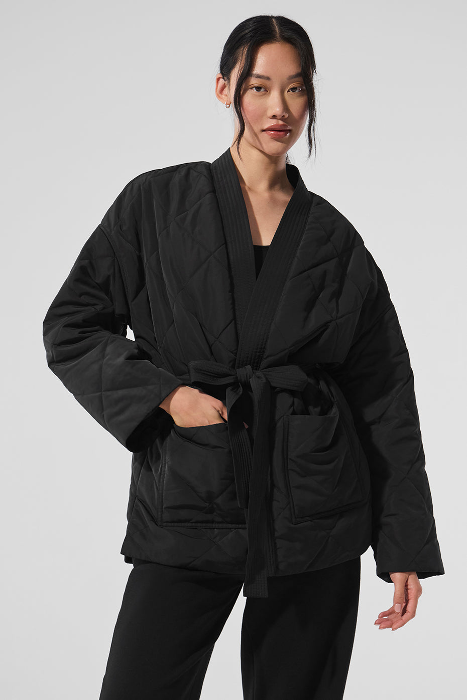Side view of woman wearing quilted quilted jacket in city snowfall