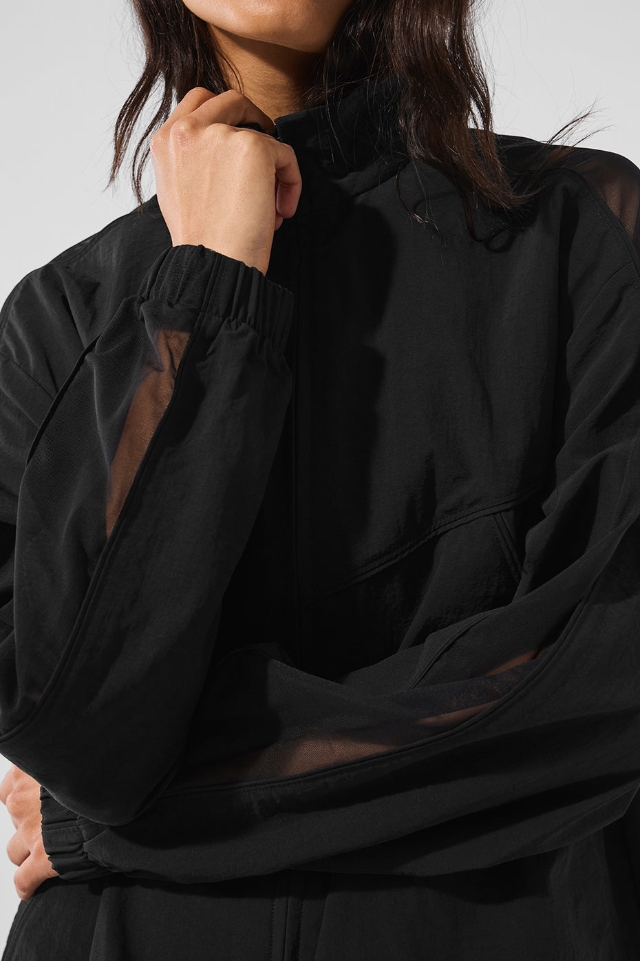Black track jacket front view showcasing mesh paneling