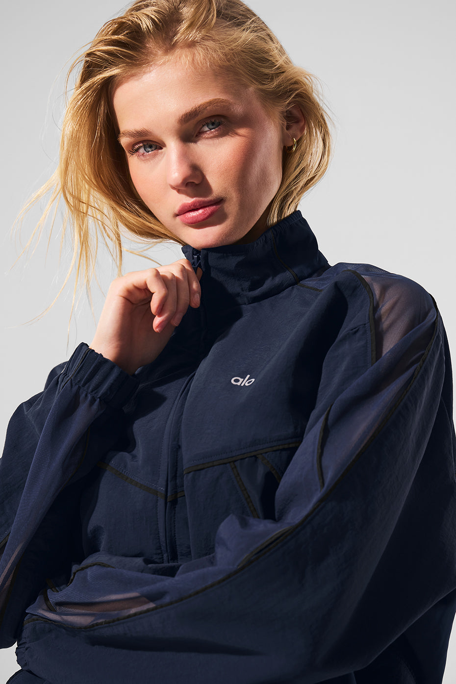Side angle of the navy and black track jacket, highlighting mesh paneling.