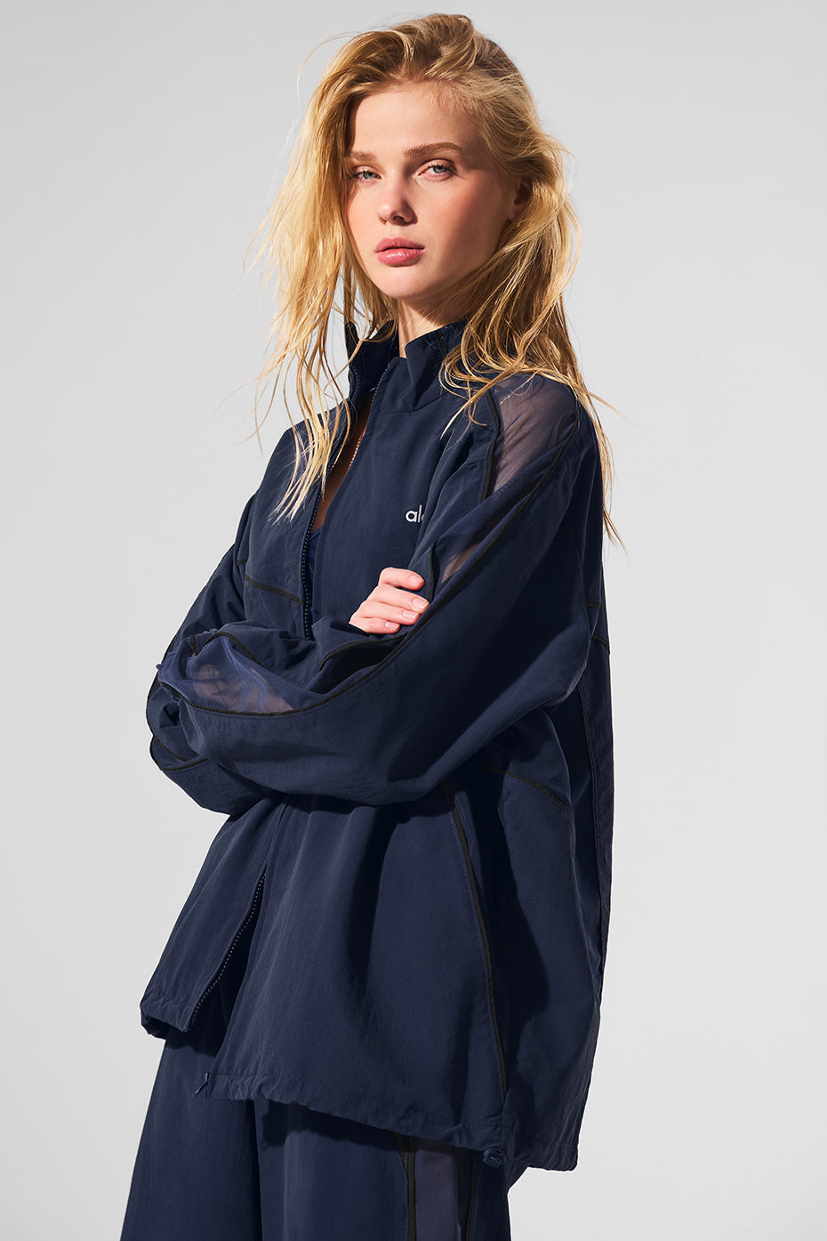 Side angle of the navy and black track jacket, highlighting mesh paneling.