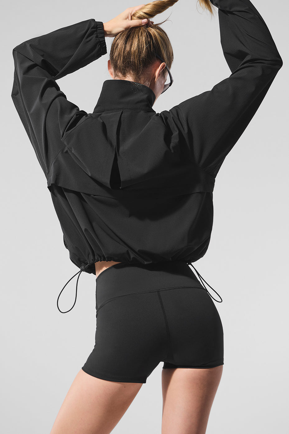 Model wearing the lightweight athletic jacket while stretching in the park