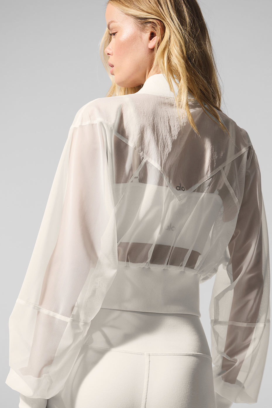 Model showcasing the relaxed fit of the ivory cropped bomber jacket.