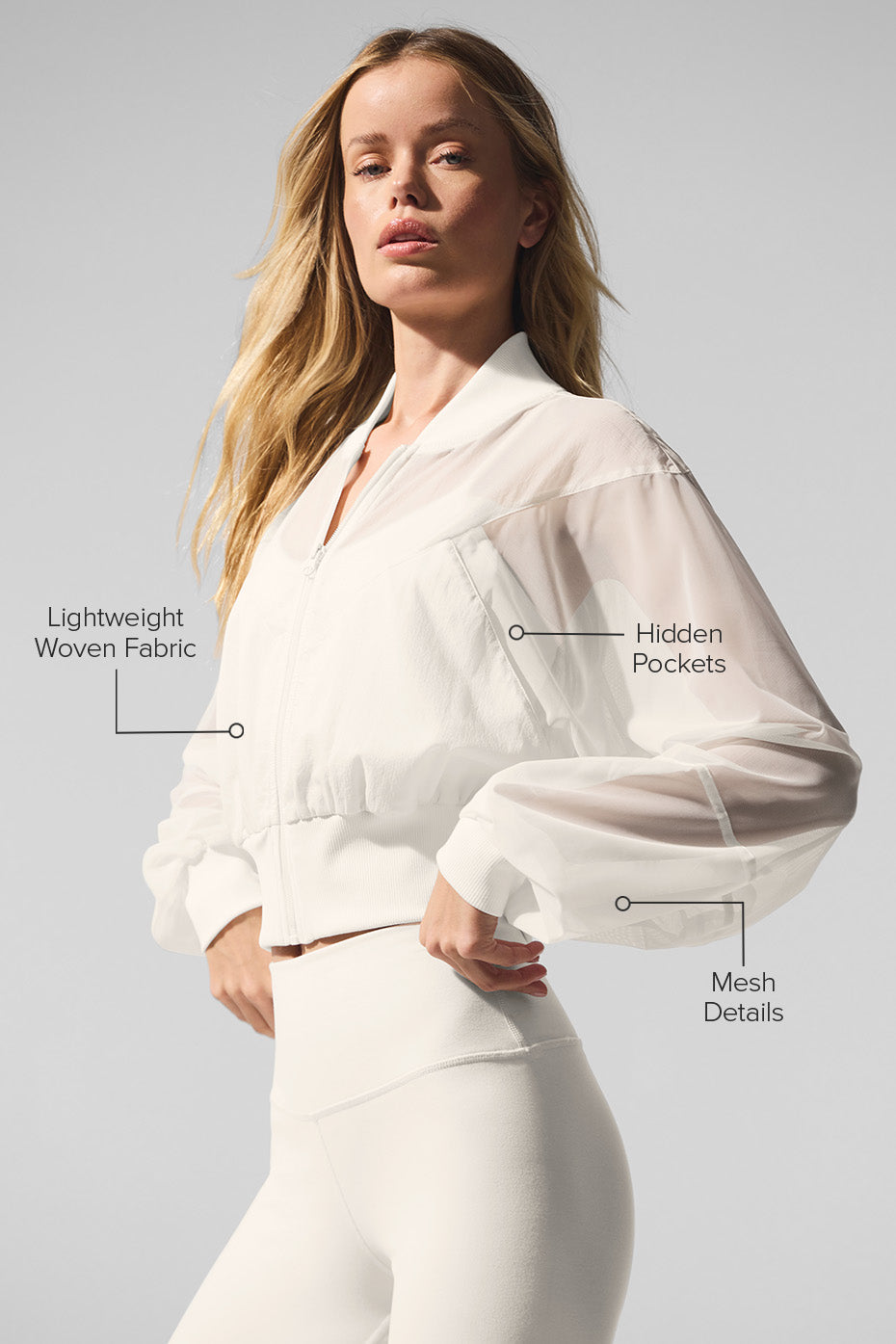 Close-up of the sheer mesh detailing on the ivory bomber jacket.